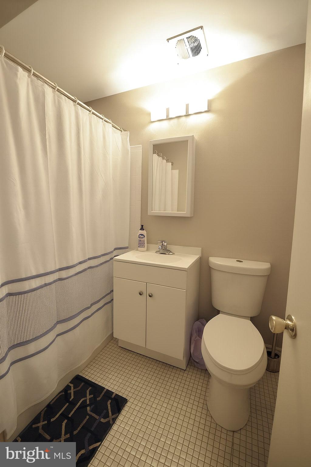 1214 Waverly Street, Unit 303 Philadelphia, PA 19147 - Photo 6 of 15 a bathroom with a toilet a sink and a mirror