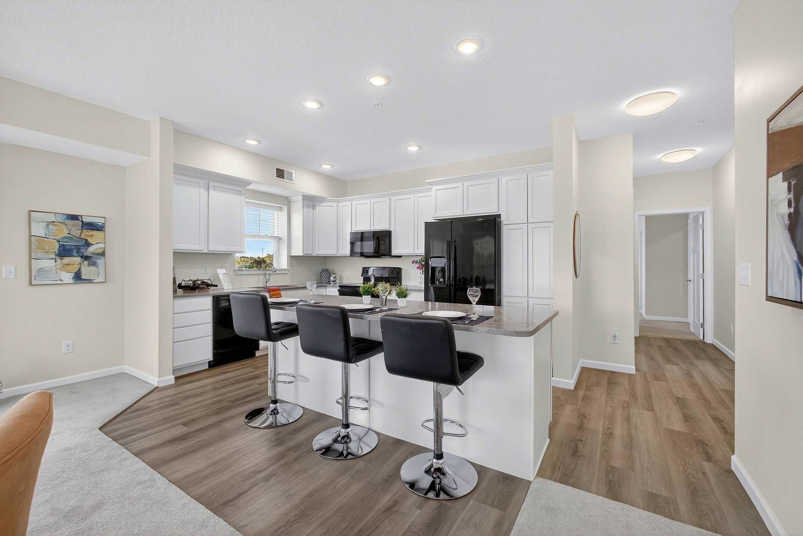 2592 Middle Road, Unit 202 Bettendorf, IA 52722 - Photo 14 of 50 a kitchen with stainless steel appliances kitchen island granite countertop a refrigerator and a stove top oven