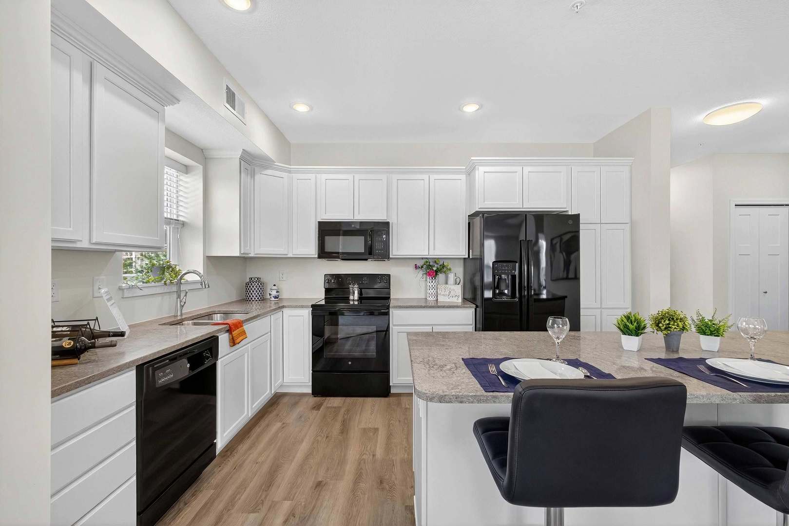2592 Middle Road, Unit 202 Bettendorf, IA 52722 - Photo 9 of 50 a kitchen with kitchen island granite countertop a sink cabinets and stainless steel appliances