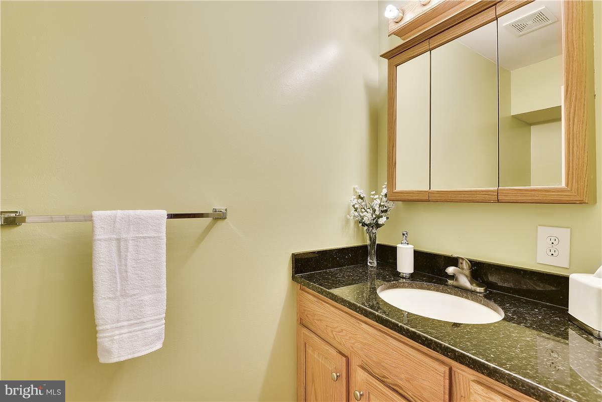 2313 Holly Spring Drive Silver Spring, MD 20905 - Photo 17 of 30 a bathroom with a granite countertop sink and a mirror