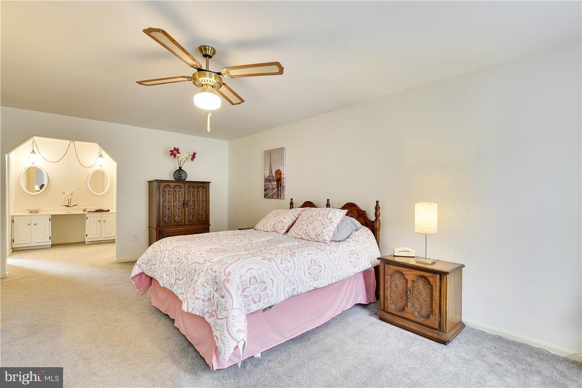 2313 Holly Spring Drive Silver Spring, MD 20905 - Photo 23 of 30 a bedroom with a bed and a chandelier