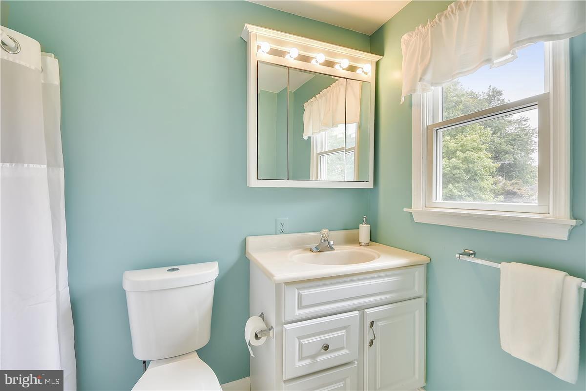 2313 Holly Spring Drive Silver Spring, MD 20905 - Photo 25 of 30 a bathroom with a toilet sink and mirror
