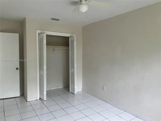 an empty room with closet and fan