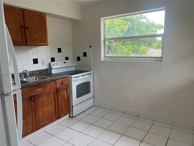 a kitchen with granite countertop a stove sink and cabinets