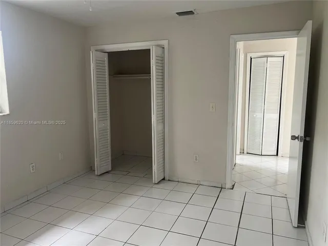 an empty room with window and closet area