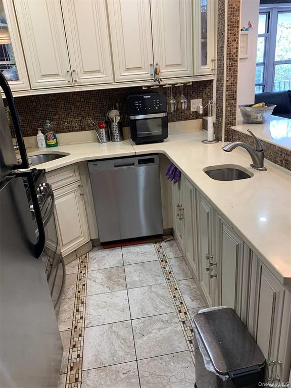 86-05 60th Road, Unit 3F Queens, NY 11373 - Photo 8 of 10 a kitchen with a sink a stove and cabinets
