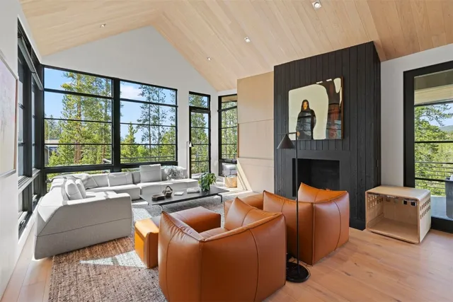 a living room with fireplace furniture and a large window