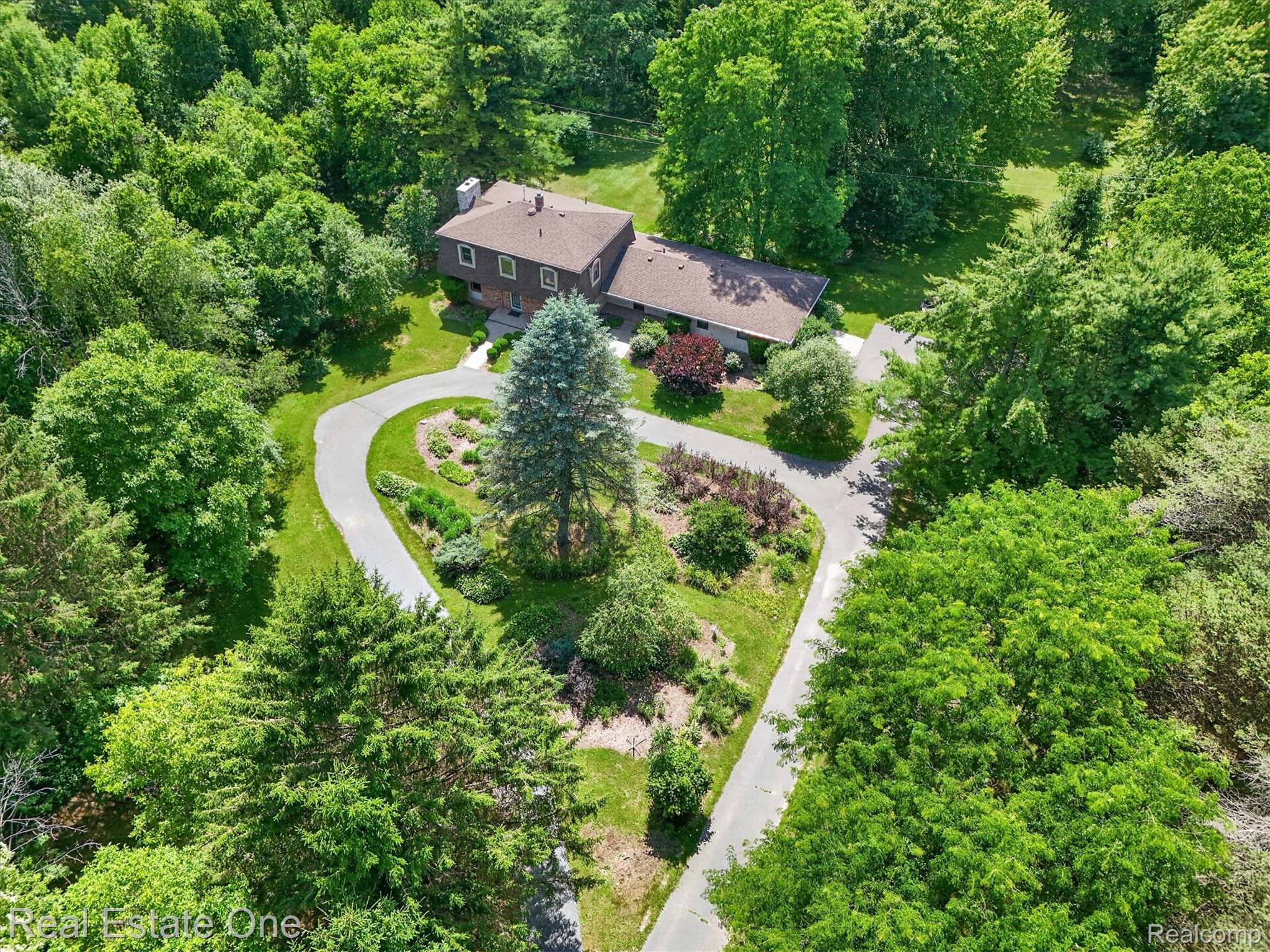 6039 Fish Lake Road Holly, MI 48442 - Photo 52 of 64 Expansive property with a brown-clad residence, surrounded by mature trees and lush greenery