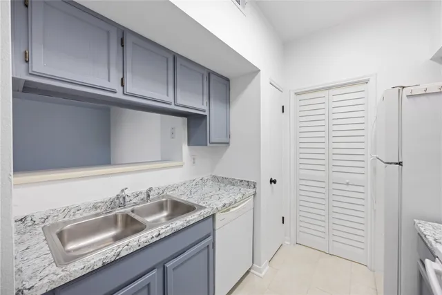 a bathroom with a granite countertop sink and white cabinets