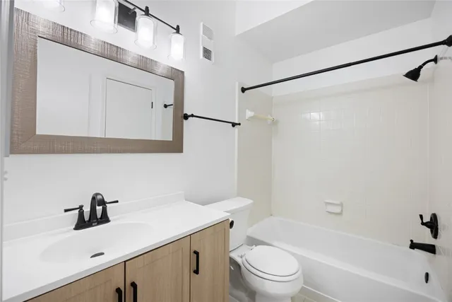 a bathroom with a sink mirror toilet and bathtub