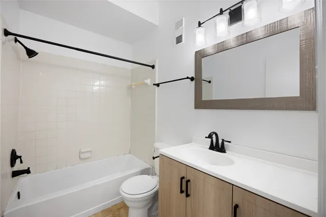 a bathroom with a sink a mirror a toilet and bathtub