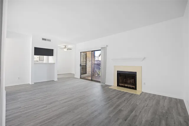 a view of empty room with wooden floor and fireplace