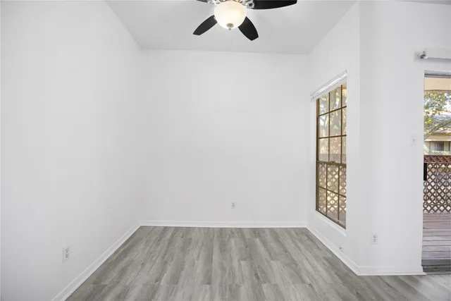 an empty room with a window and wooden floor