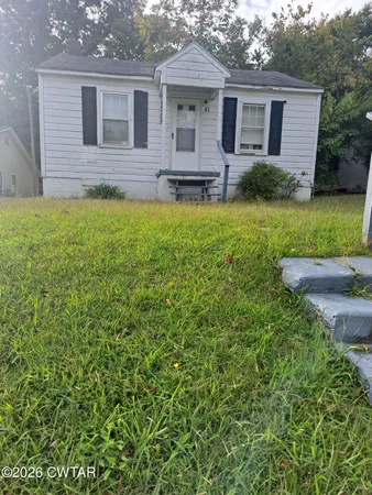 a front view of a house with yard and green space
