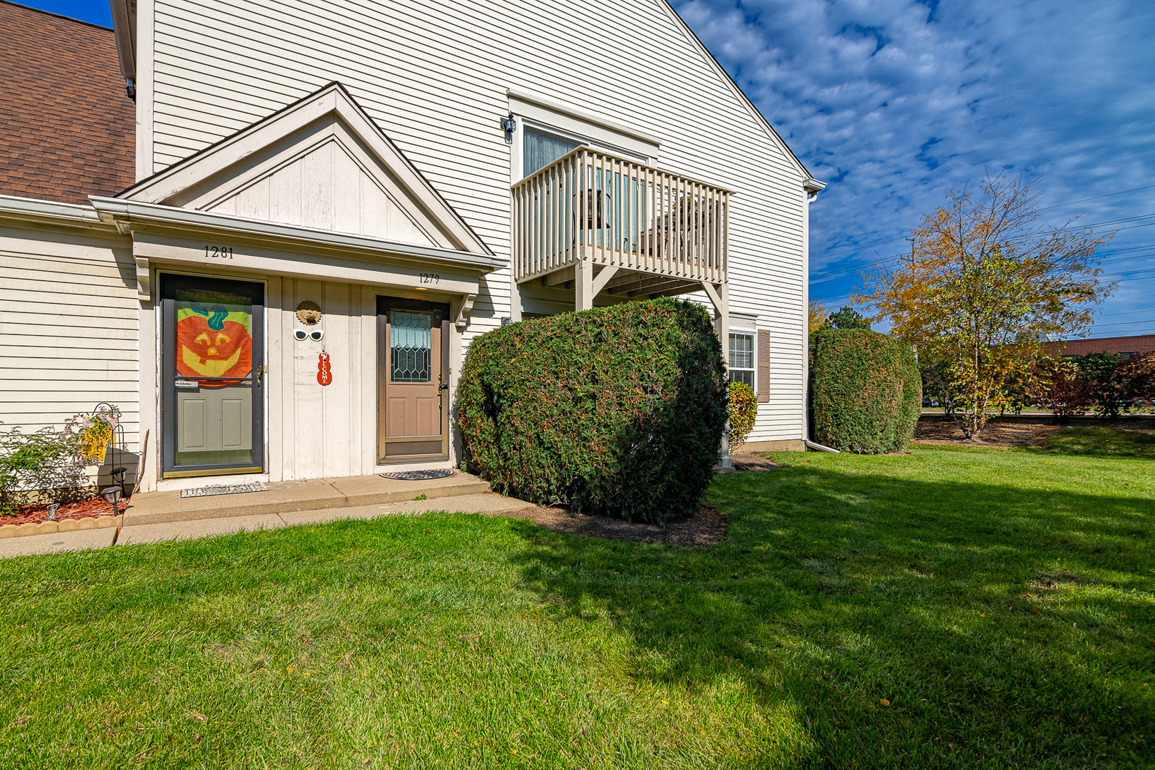 1279 Longacre Lane, Unit 1279 Wheeling, IL 60090 - Photo 14 of 14 a front view of a house with a garden and plants