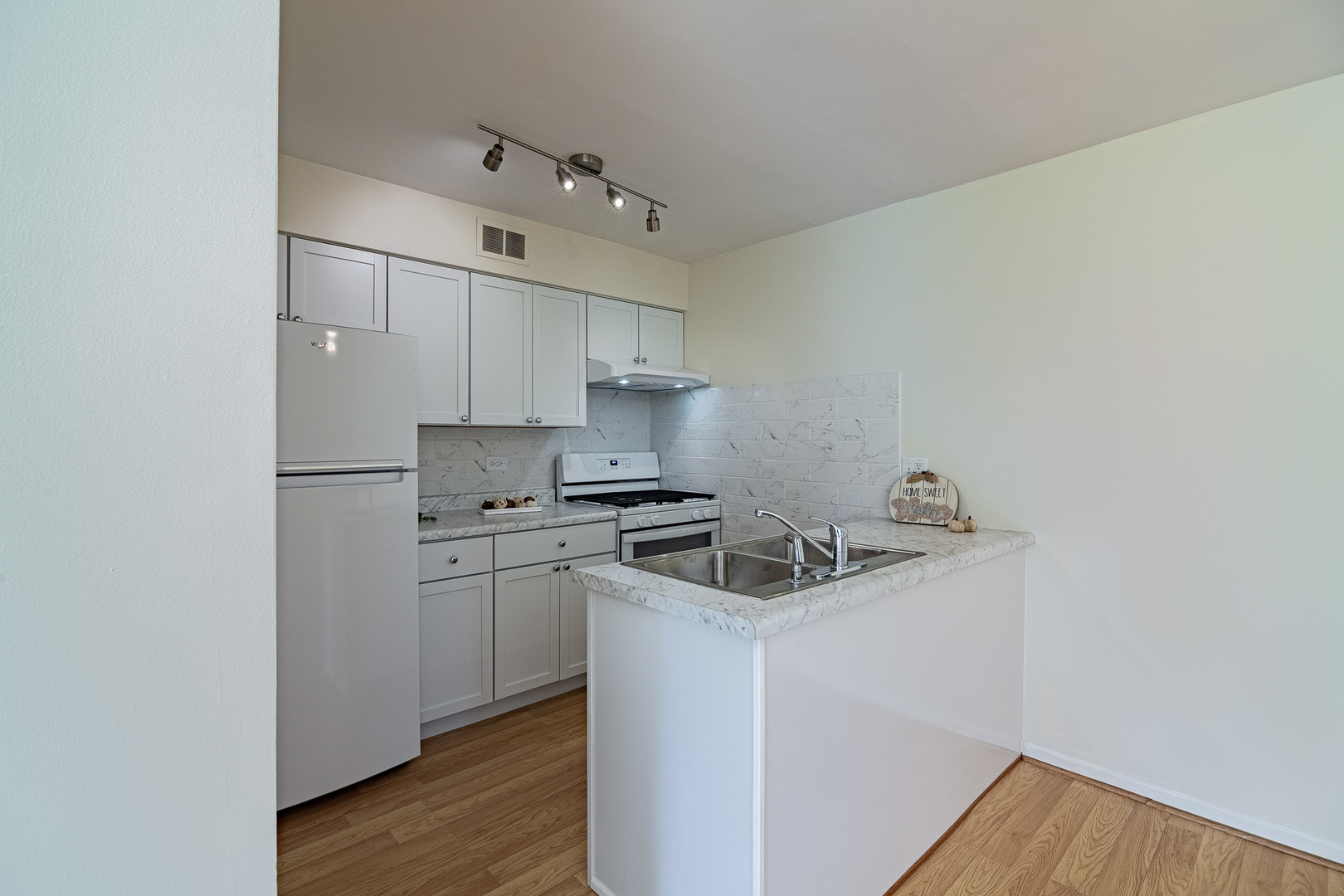 1279 Longacre Lane, Unit 1279 Wheeling, IL 60090 - Photo 4 of 14 a kitchen with stainless steel appliances granite countertop a sink stove and refrigerator