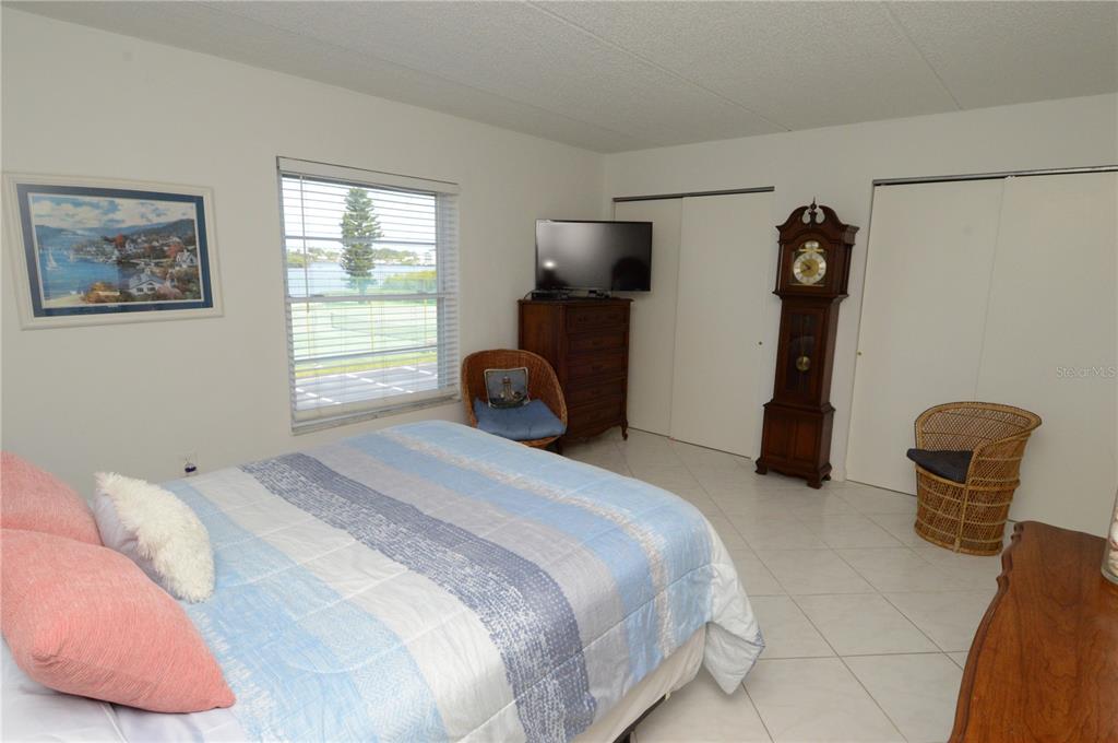 12760 Indian Rocks Road, Unit 1031 Largo, FL 33774 - Photo 29 of 85 a bedroom with a bed and a chair with the potted plant