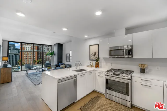 a large white kitchen with stainless steel appliances