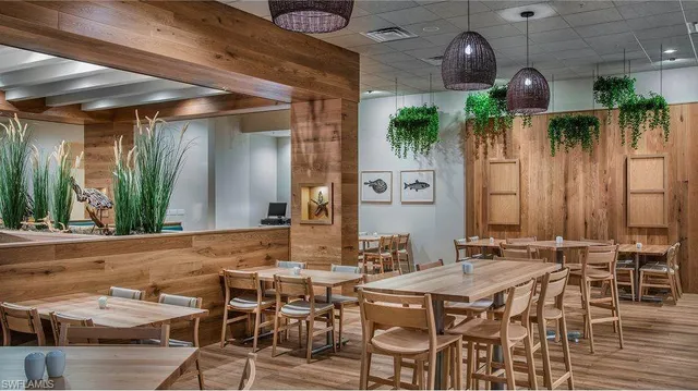 a dining room with furniture and a potted plant