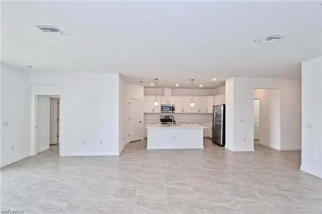 a view of a kitchen with refrigerator sink and cabinets