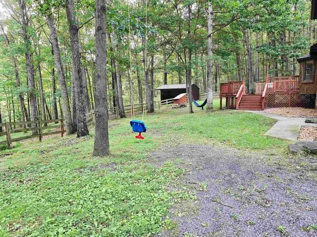 a backyard of a house with swing and slide