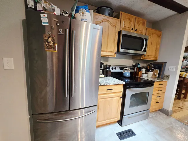 a kitchen with stainless steel appliances a refrigerator stove and microwave