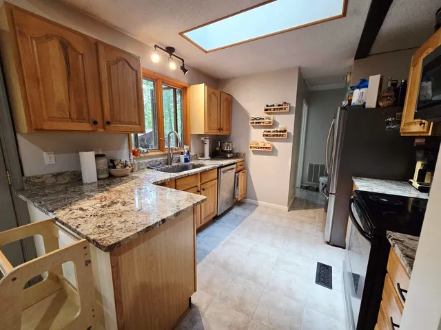a kitchen with stainless steel appliances granite countertop a sink stove and refrigerator