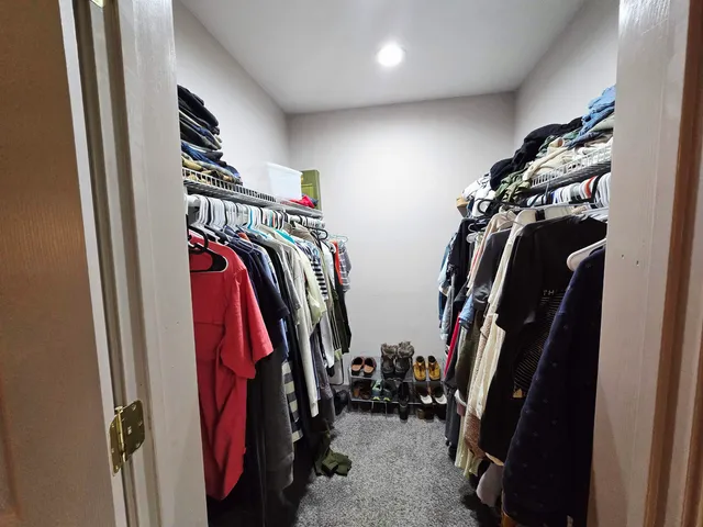 a view of walk in closet with clothes