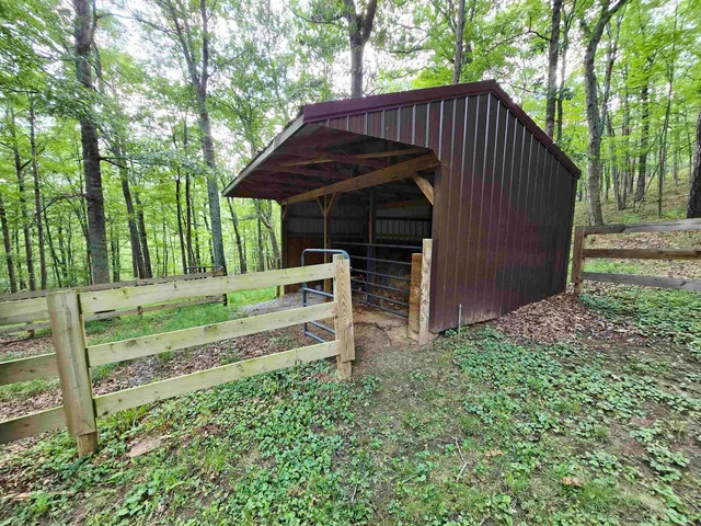 a view of a small house with wooden fence