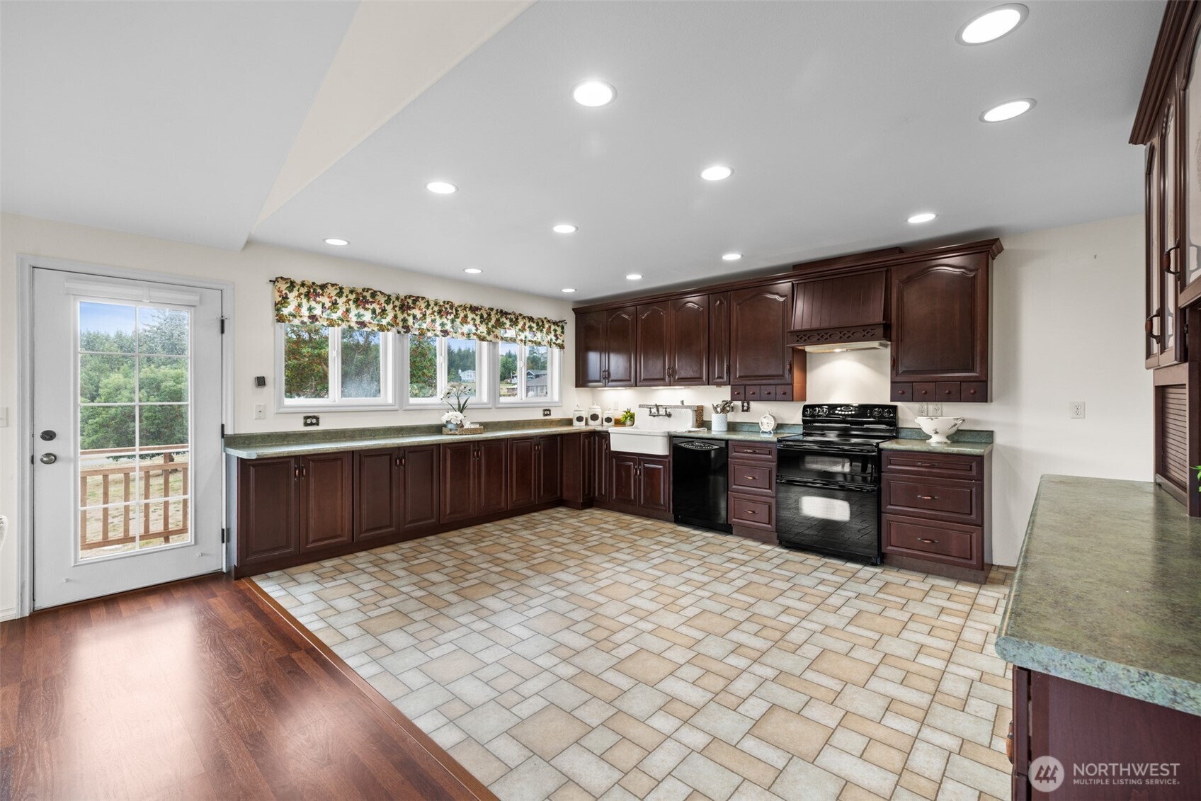 382 Discovery View Drive Sequim, WA 98382 - Photo 11 of 40 a kitchen with stainless steel appliances granite countertop a refrigerator a sink dishwasher a stove oven and a dining table with wooden floor
