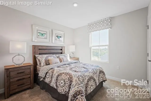 a bedroom with a bed and painting on the wall