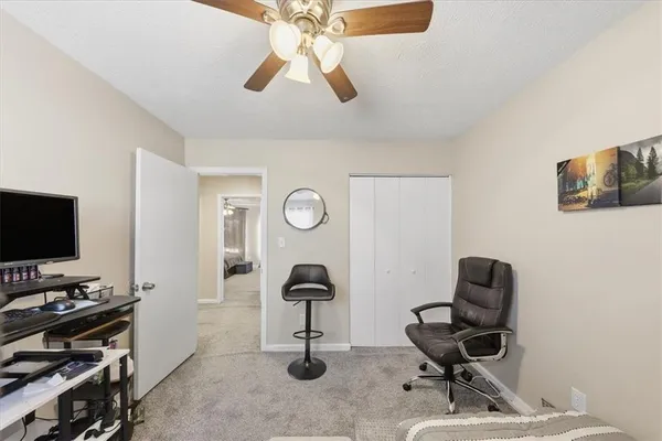 a view of a workspace with furniture and a window