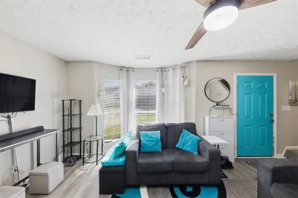 a living room with furniture a flat screen tv and a large window