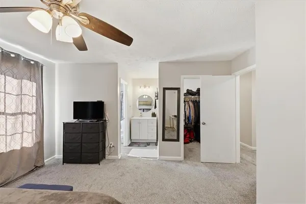 a view of a livingroom with entryway closet and a ceiling fan