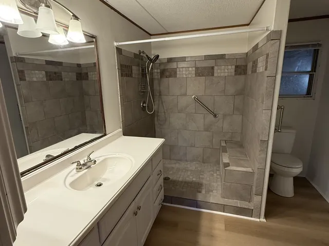 a bathroom with a sink a toilet and shower