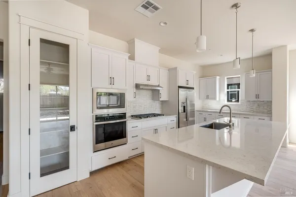 a kitchen with stainless steel appliances granite countertop a refrigerator and a stove top oven