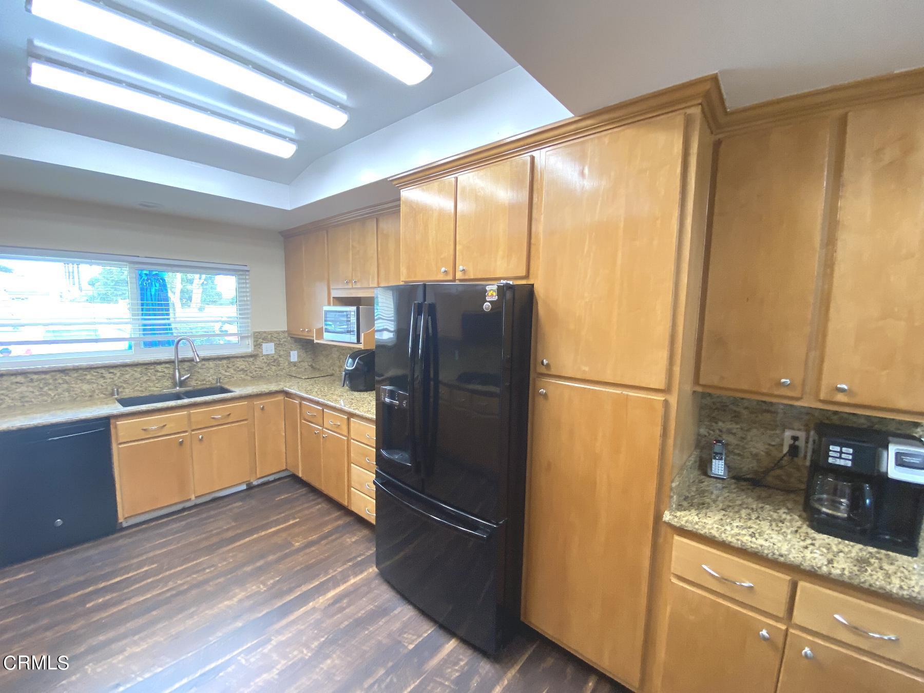 4520 Reeder Avenue Oxnard, CA 93033 - Photo 13 of 28 a kitchen with granite countertop stainless steel appliances a refrigerator cabinets and wooden floor
