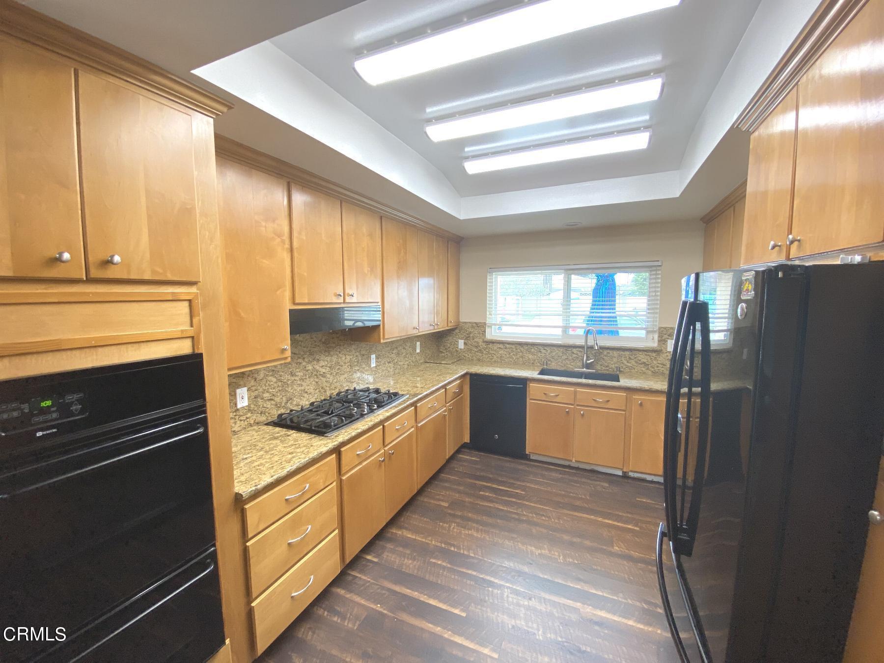 4520 Reeder Avenue Oxnard, CA 93033 - Photo 7 of 28 a kitchen with a refrigerator a sink and cabinets