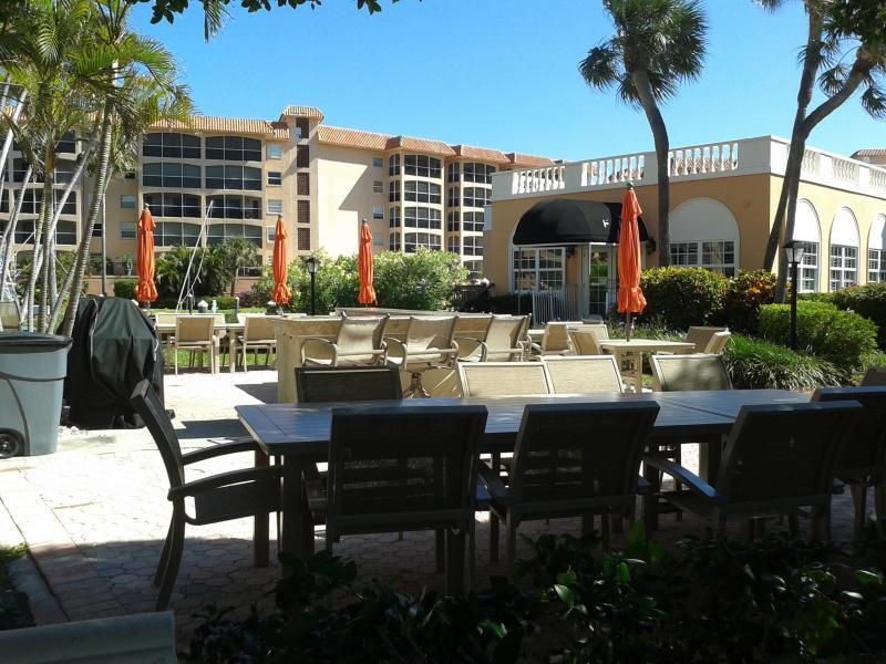2871 North Ocean Boulevard, Unit V457 Boca Raton, FL 33431 - Photo 28 of 42 a view of a patio with table and chairs potted plants and palm tree