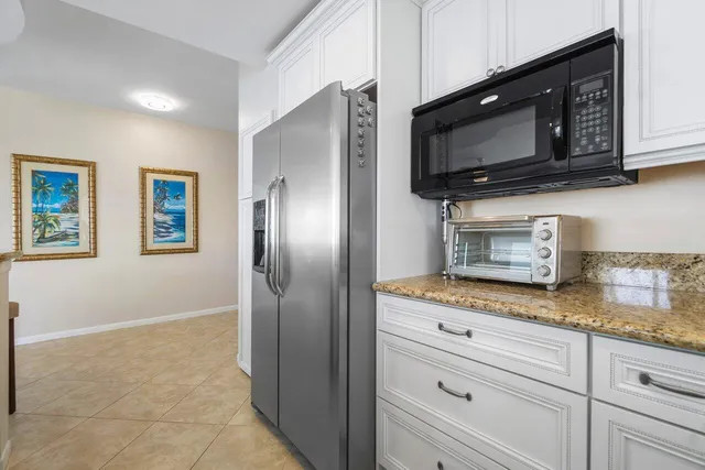 a kitchen with granite countertop stainless steel appliances a stove microwave and refrigerator
