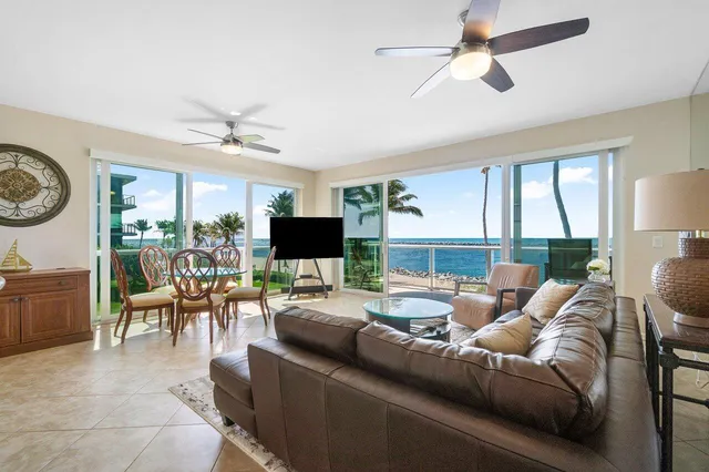 a living room with furniture a flat screen tv and a large window