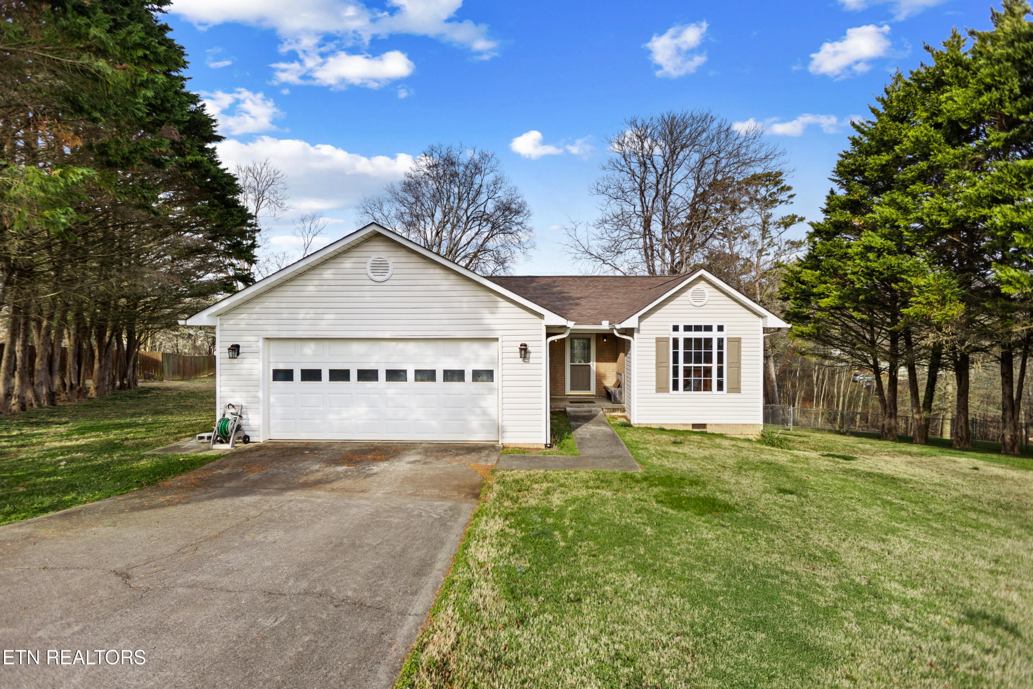 a view of white house with a yard and large trees