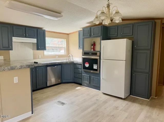 a kitchen with stainless steel appliances a refrigerator sink and cabinets