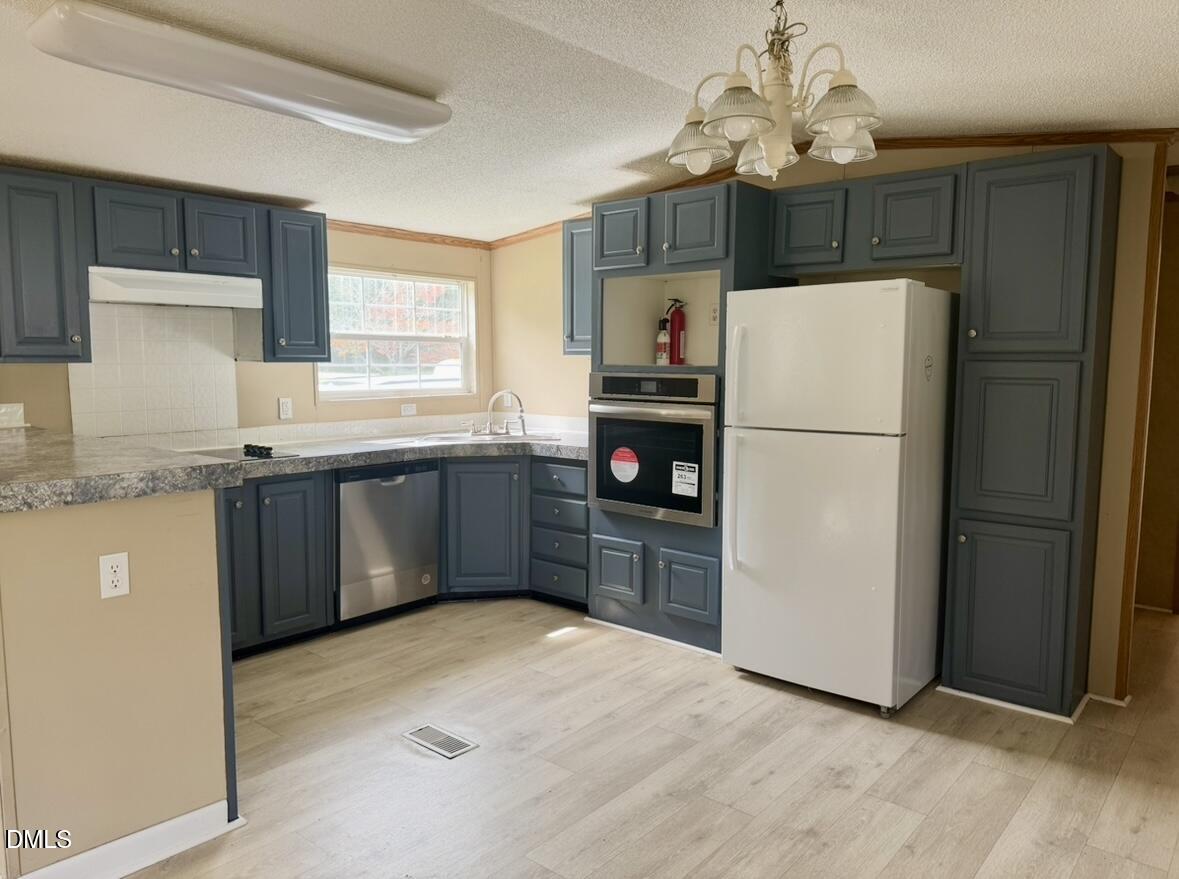 9614 Dunn Road Godwin, NC 28344 - Photo 4 of 9 a kitchen with stainless steel appliances a refrigerator sink and cabinets