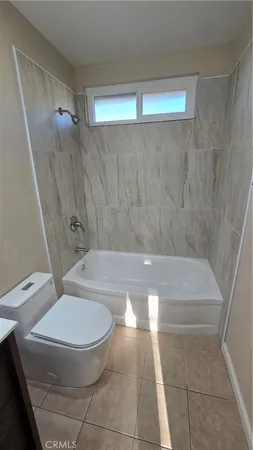 a bathroom with a toilet and a bath tub
