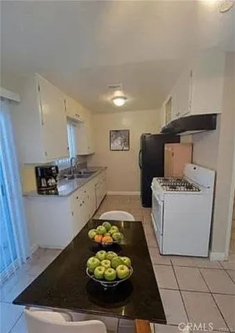 a kitchen with stainless steel appliances kitchen island granite countertop a stove a sink and a refrigerator