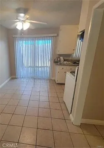 a view of a kitchen with a stove top oven cabinets and a window