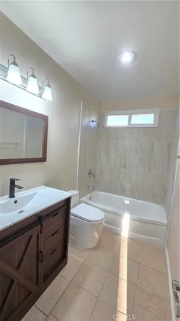 a bathroom with a double vanity sink a toilet a mirror and bathtub