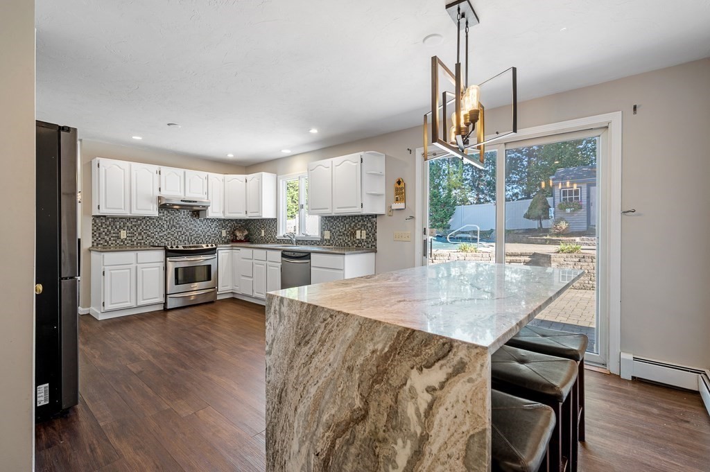 8 Hyde Street Worcester, MA 01606 - Photo 11 of 36 a kitchen with stainless steel appliances granite countertop a stove top oven a sink and a refrigerator