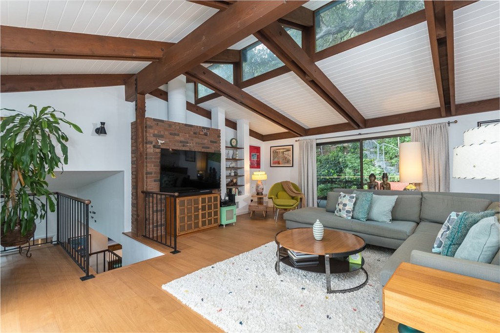 a living room with furniture a flat screen tv and a large window
